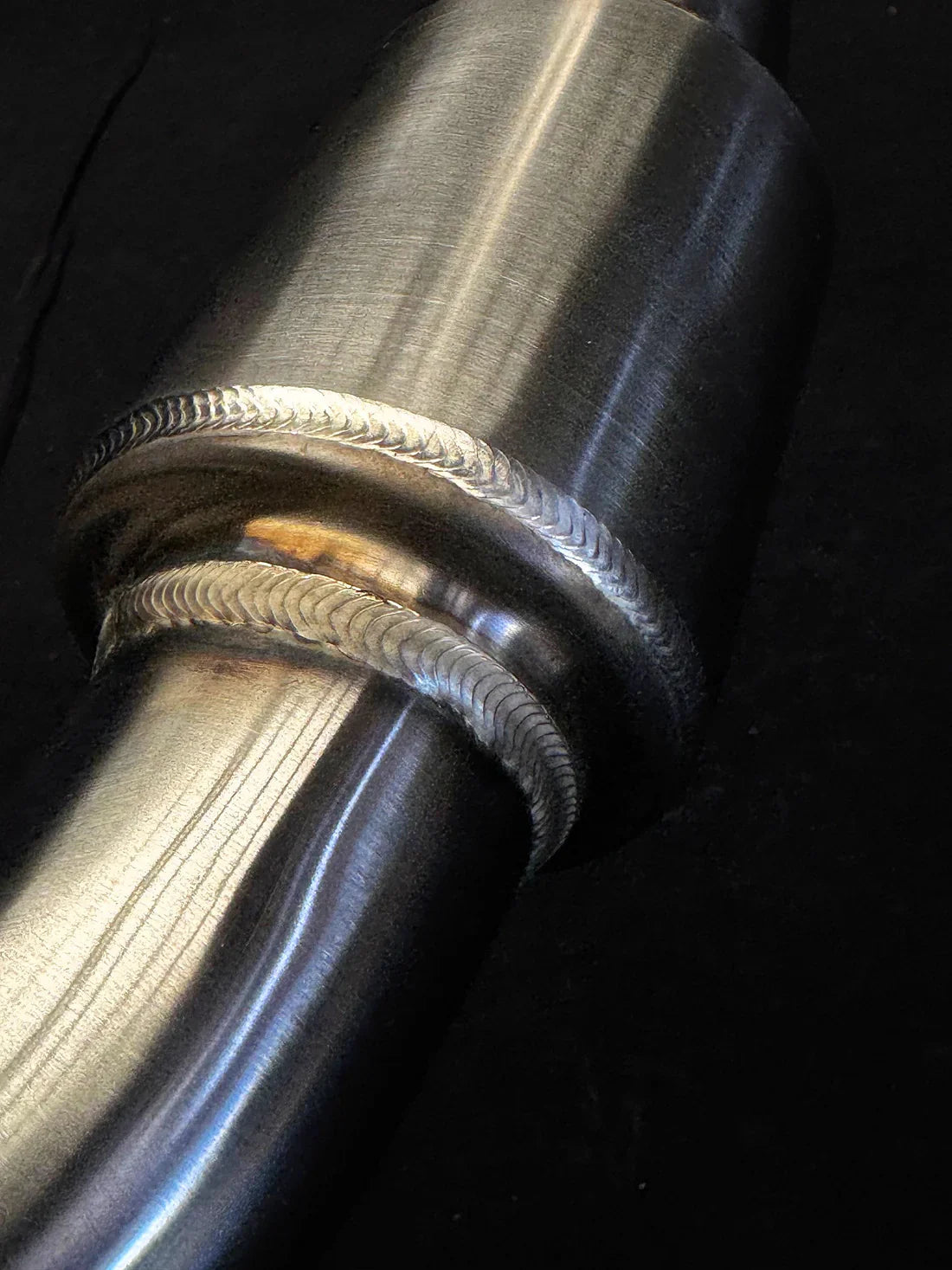Stainless steel welds on Vandemon Triumph Tiger 850-900 full exhaust system by Bill's Exhausts, showing polished metal and welding details.