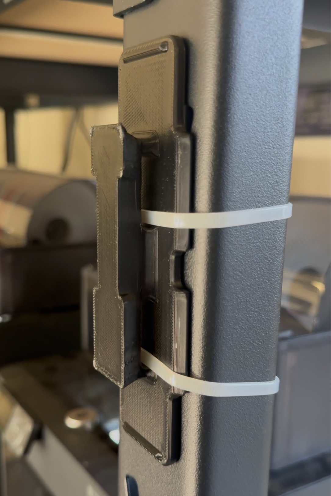 Universal mount plate accessory by McCoy Industries, showing a flat metal mounting plate with screw holes for versatile use.