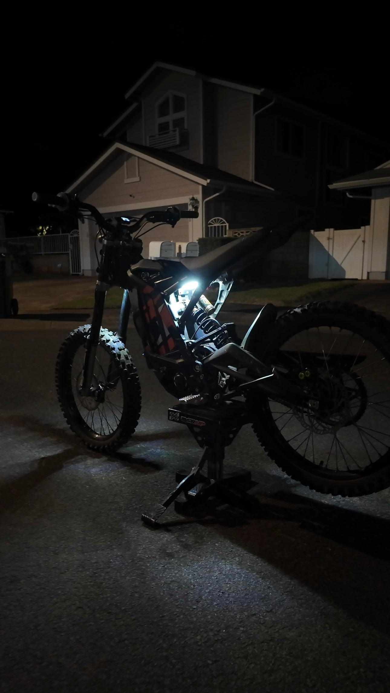 White Surron underglow rear kit from Project9, featuring LED lights installed on the back of the electric dirt bike.