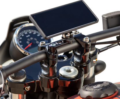 Black SP CONNECT Pro Phone Mount handlebar clamp attached to a motorcycle handlebar, securely holding a smartphone in place.