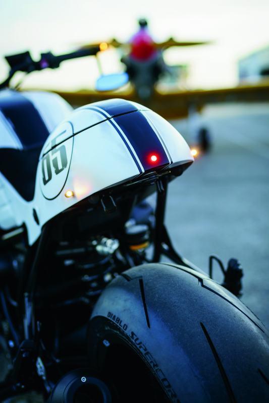 Kuryakyn Kellerman Atto smoke lens red run-brake light mounted on motorcycle, compact LED signal with sleek smoke lens.