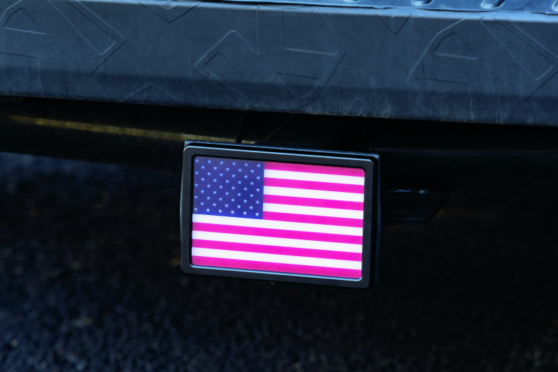 Kuryakyn Freedom Flag LED hitch cover in black for 1-1/4 inch and 2 inch receiver hitches, featuring LED lights and flag design.