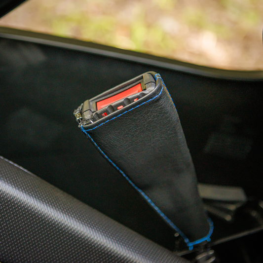 Bill's Exhausts Show Chrome seat belt covers in black with blue stitching, designed for engine safety and style.