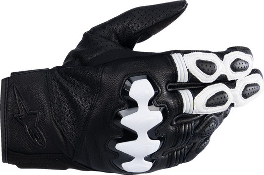 Alpinestars Celer V3 motorcycle gloves in black and white, medium size, with textured knuckles and adjustable wrist closure.