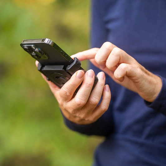 SP CONNECT Phone Holder Kit SPC+ universal clamp mounted on a vehicle, compatible with various smartphones for secure attachment.