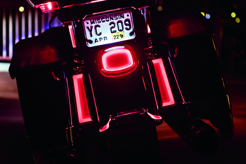 Kuryakyn Tracer LED taillight with red lens and license plate light installed on Harley Davidson motorcycle.