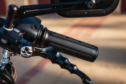 Kuryakyn Heavy Industry black grips with dual cables for powersports vehicles, part #6121, shown on motorcycle handlebar.