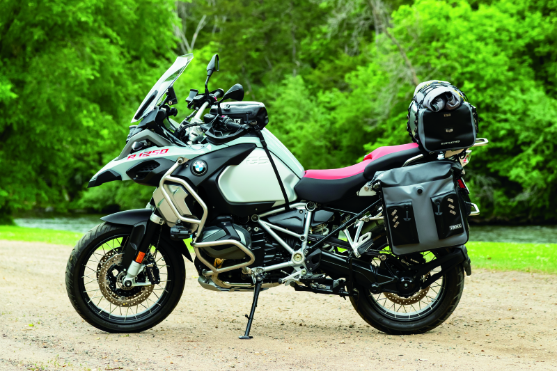 Kuryakyn Torke 7L dry tank bag with backpack straps, waterproof design, mounted on motorcycle tank, with multiple compartments