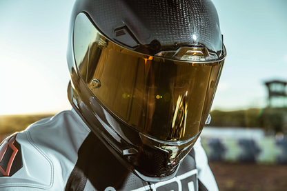 Carbon ICON Airframe Pro helmet in gold with small size, featuring aerodynamic design and ventilation for motorcycle riding.