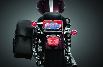 Kuryakyn license plate turn signal and marker light mount in chrome, designed for motorcycle customization.