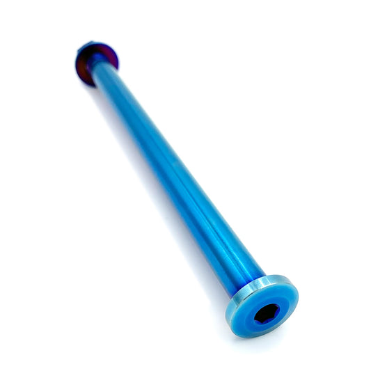 Blue titanium rear axle for Surron LBX electric bike, made by eDirtyBike, shown installed on the bike frame.