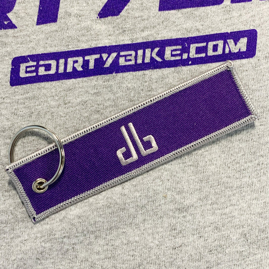 eDirtyBike key chain featuring the DirtyBike logo, made of durable material, shown from the back with detailed branding.