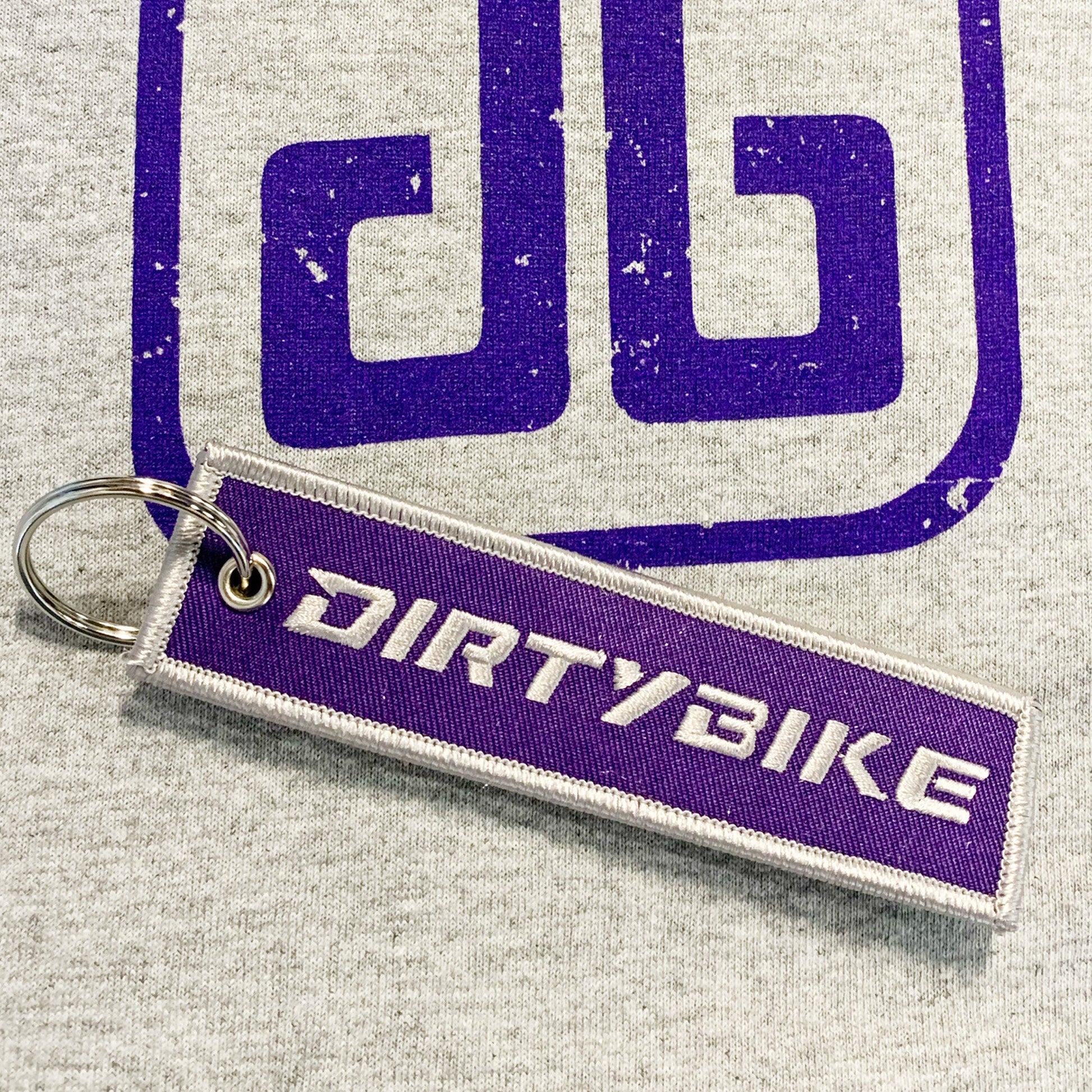 eDirtyBike key chain featuring a durable metal design with the DirtyBike logo, ideal for attaching to keys or bags.