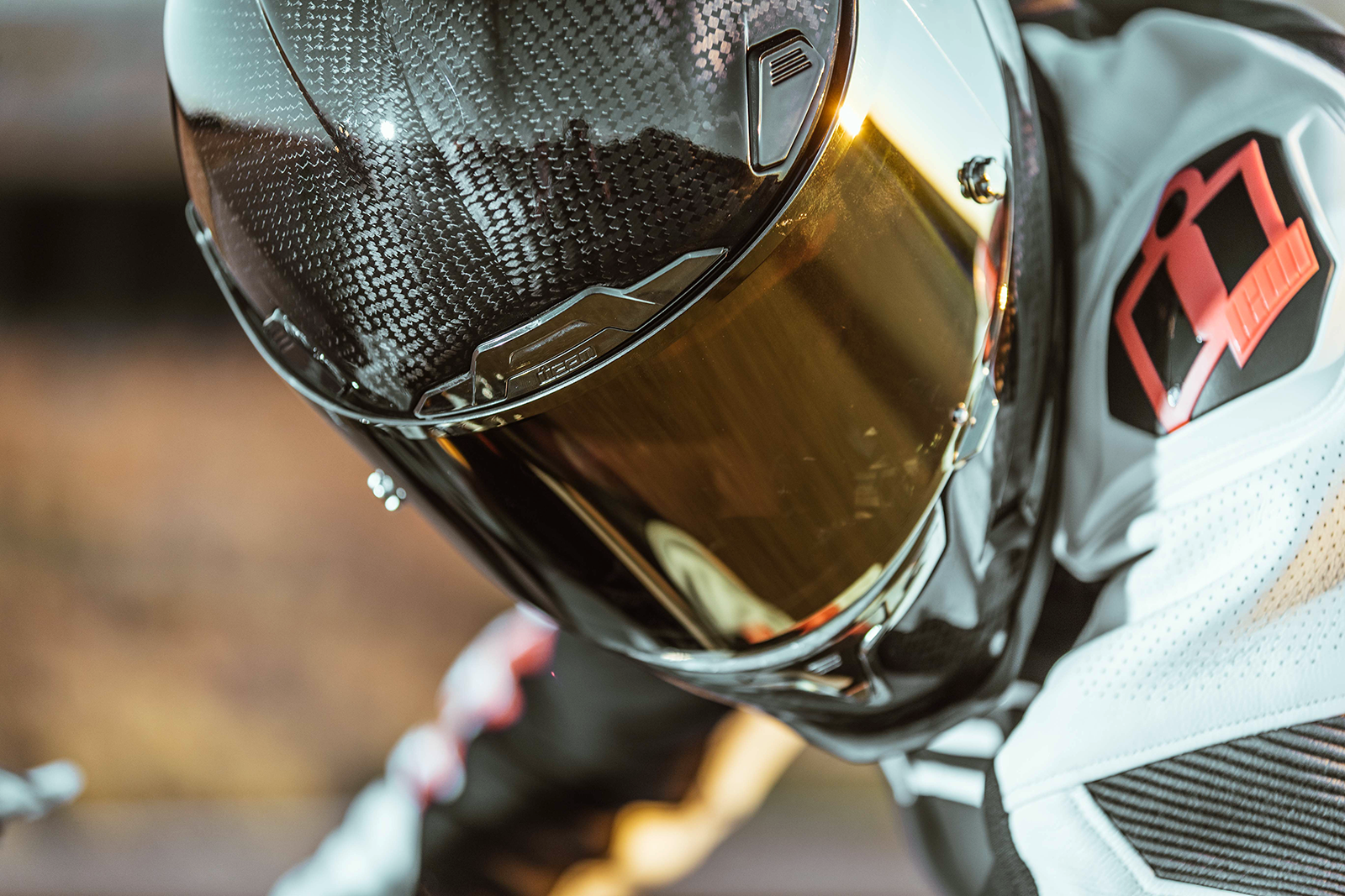Bill's Exhausts ICON Airframe Pro™ helmet in carbon with gold finish, small size, front view showing sleek aerodynamic design.