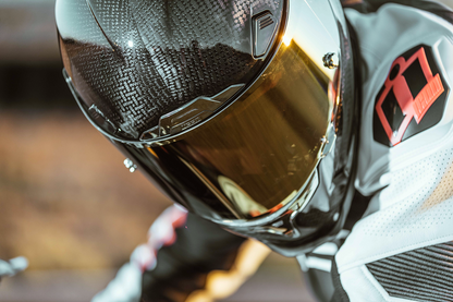 Bill's Exhausts ICON Airframe Pro™ helmet in carbon with gold finish, small size, front view showing sleek aerodynamic design.