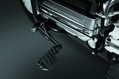 Kuryakyn Ergo III adjustable cruise mount with Trident Dually ISO pegs in gloss black, mounted on motorcycle handlebar.