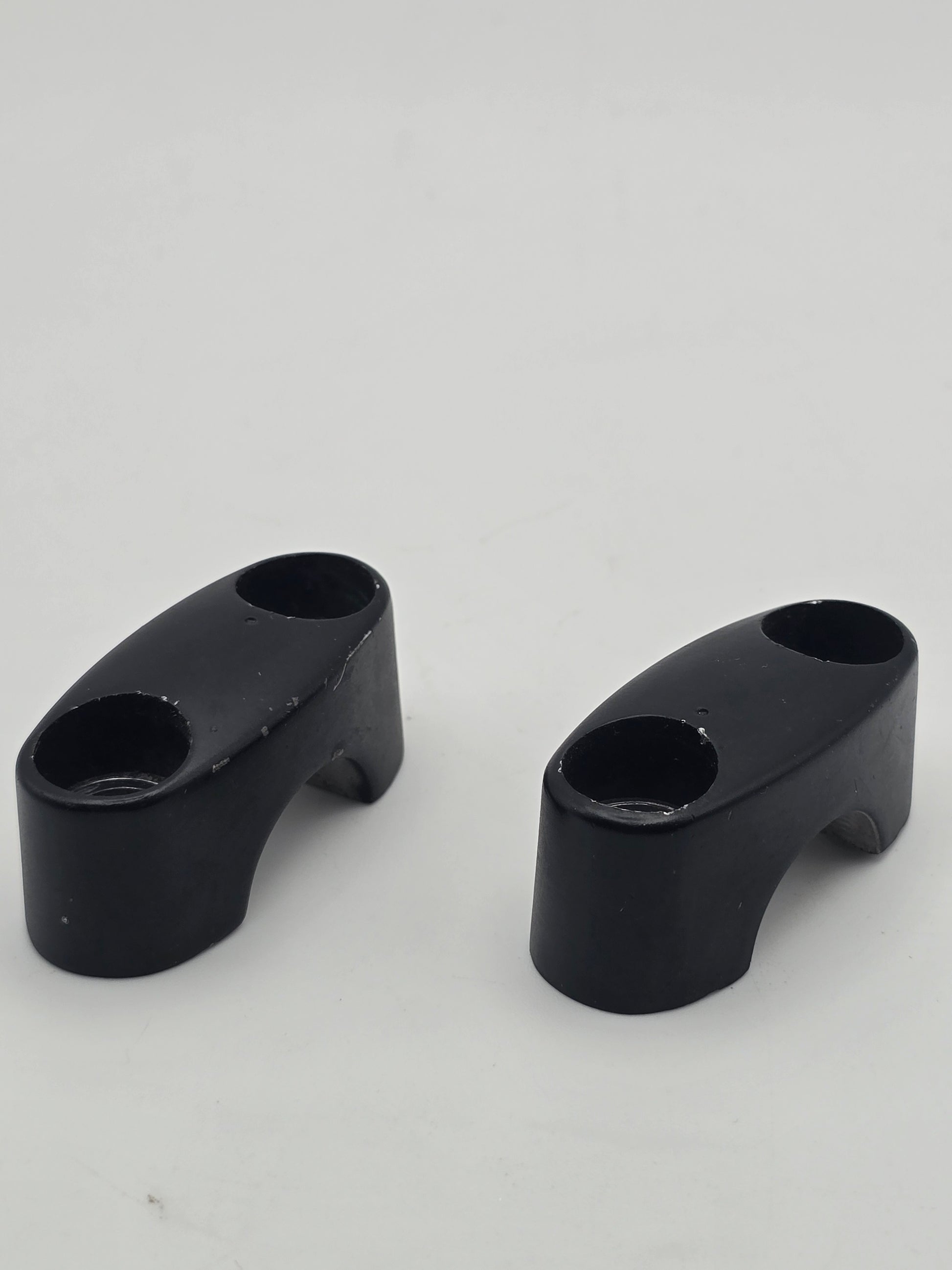 Pair of used Honda Grom OEM handlebar mounts for 2014-2020, durable handlebar holder brackets in good condition.