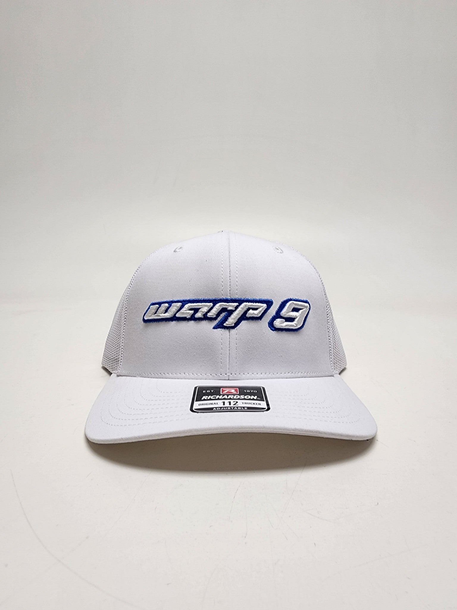 White and blue WarpWear W9 hat with adjustable strap and embroidered Warp9Racing logo, stylish apparel for racing fans.