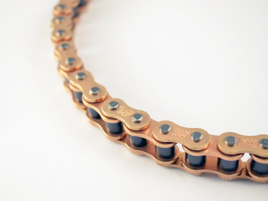 Warp9Racing E-Moto 428 chain, durable motorcycle chain, shown with links and sprocket engagement in a detailed close-up image.