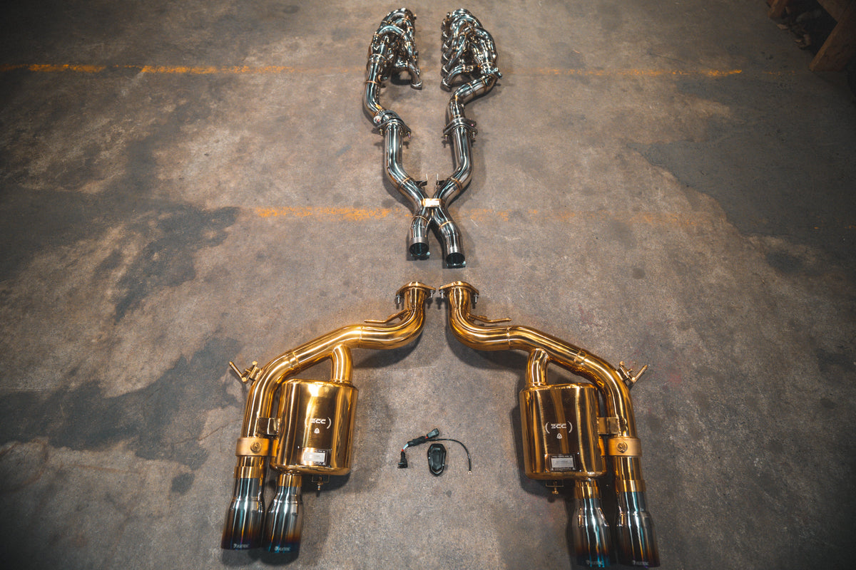 Ferrari 599 race F1 valved exhaust system by Valvetronic Designs, showing polished metal exhaust pipes and valve components.