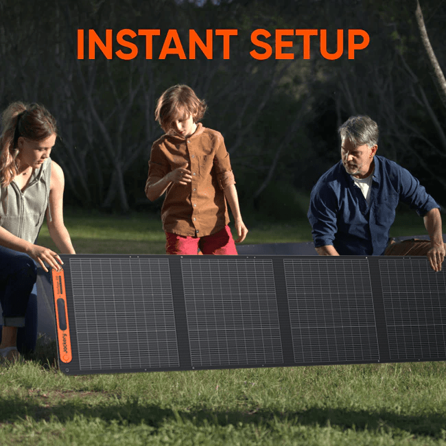 Jackery SolarSaga 200W solar panel outdoors with sunlight reflecting off its black surface and foldable design.