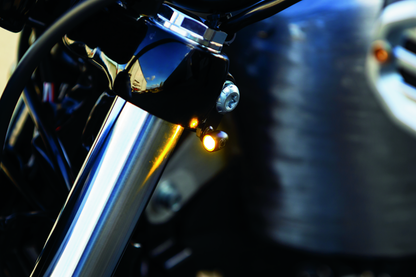 Kuryakyn Kellermann Atto clear lens amber LED motorcycle turn signals in satin black mounted on a motorcycle.