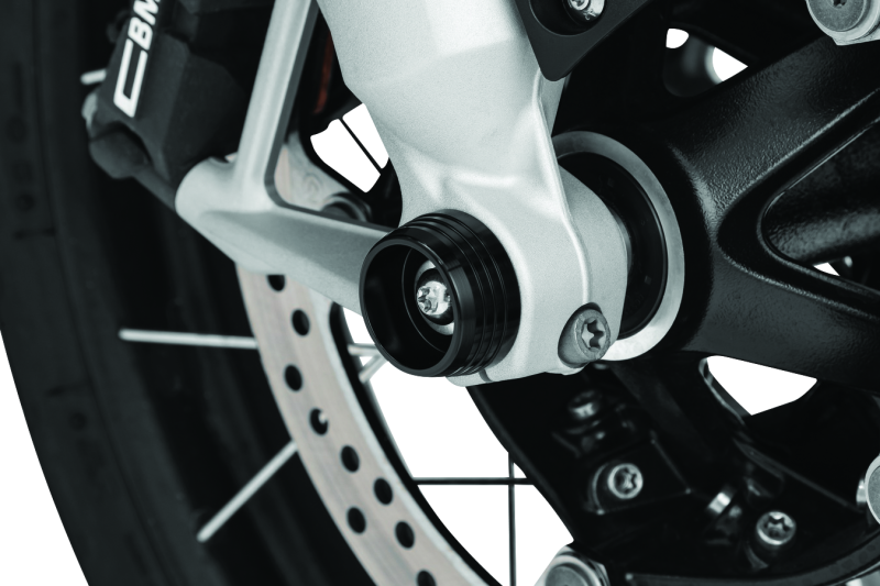 Kuryakyn Lodestar front axle sliders installed on BMW R1200GS and RT motorcycle models, showing protective gear for the front axle.