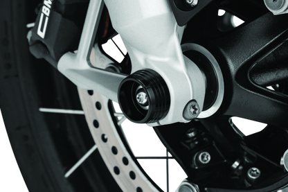 Kuryakyn Lodestar front axle sliders installed on BMW R1200GS and RT motorcycle models, showing protective gear for the front axle.