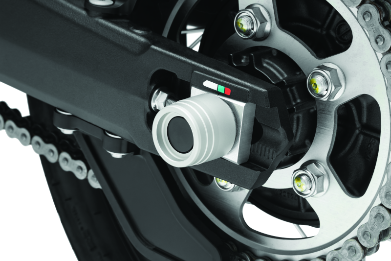 Kuryakyn rear axle slide for Honda CRF1000L Africa Twin and Adventure Sports motorcycle, part #3827, shown on a motorcycle wheel.