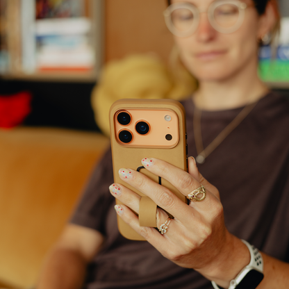 Peak Design Everyday Loop Case for iPhone 17 Pro in tan, showing the sleek mobile phone with protective case and loop attachment