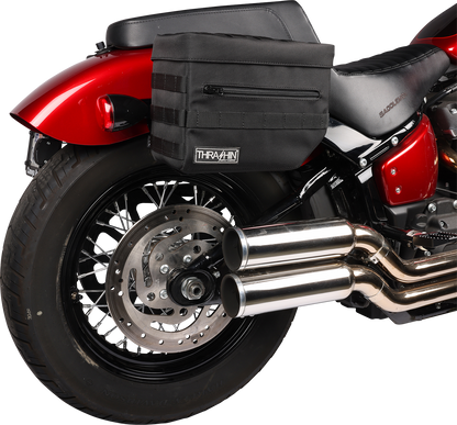 Black THRASHIN SUPPLY CO. Essential Saddlebags TSB-0006 with 10-liter storage capacity, shown on motorcycle with secure straps.