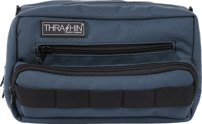 Blue THRASHIN SUPPLY CO. Handlebar Bag Plus mounted on a bicycle handlebar, showcasing its compact design and secure attachment system.