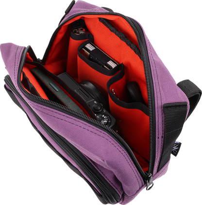 Purple THRASHIN SUPPLY CO. Handlebar Bag Plus mounted on a bicycle handlebar, showcasing its compact, durable design.