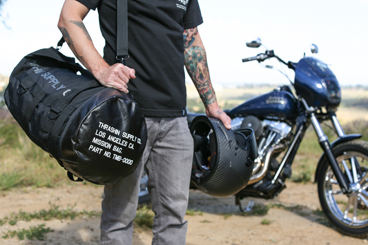 Black THRASHIN SUPPLY CO. Mission Duffel Bag with sturdy handles and spacious main compartment, ideal for travel and sports use.