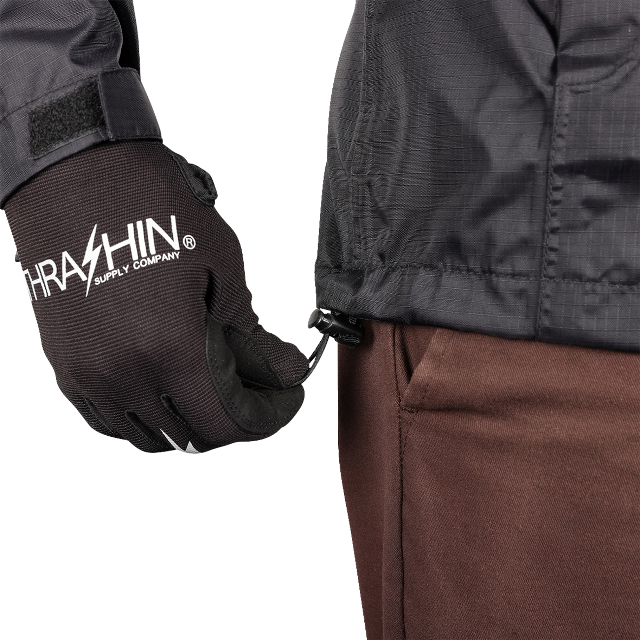 Black THRASHIN SUPPLY CO. Mission WP Rain Jacket in medium size, shown on a hanger with front zipper and hood.