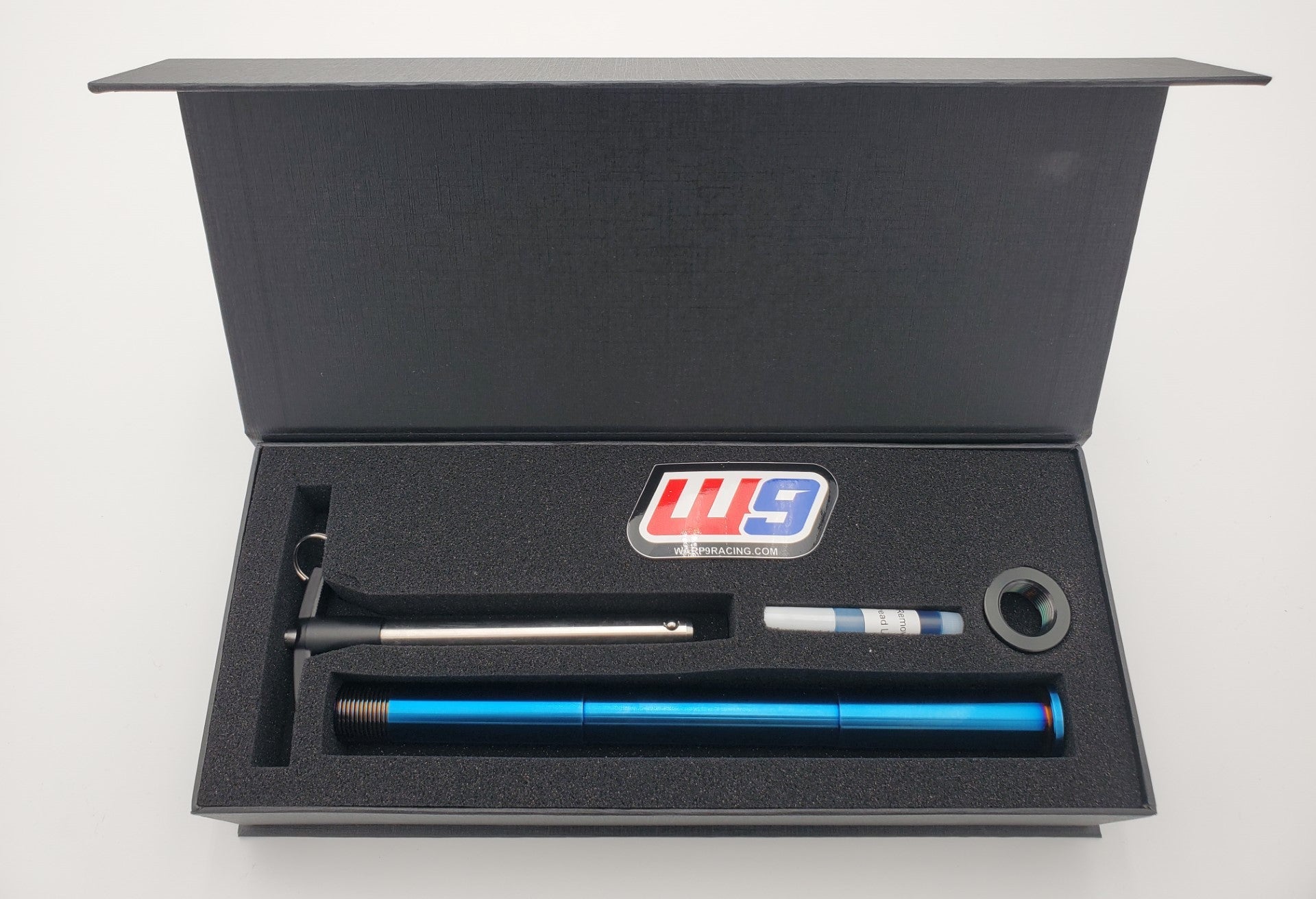 Warp9Racing Surron Ultra Bee Titanium Rear Axle, compact thumbnail image showing high-strength motorcycle part.
