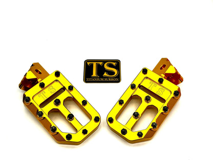 Titanium Surron custom titanium grip footpegs with textured grips for Surron and light e-moto bikes, including Talaria and Altis models.
