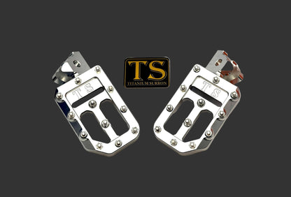 Titanium Surron custom foot pegs with titanium grips for Surron and light e-moto bikes, featuring durable metal construction and textured grips.