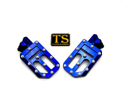 Titanium Surron custom foot pegs with titanium grips for Surron and light e-moto bikes, featuring durable metal construction.
