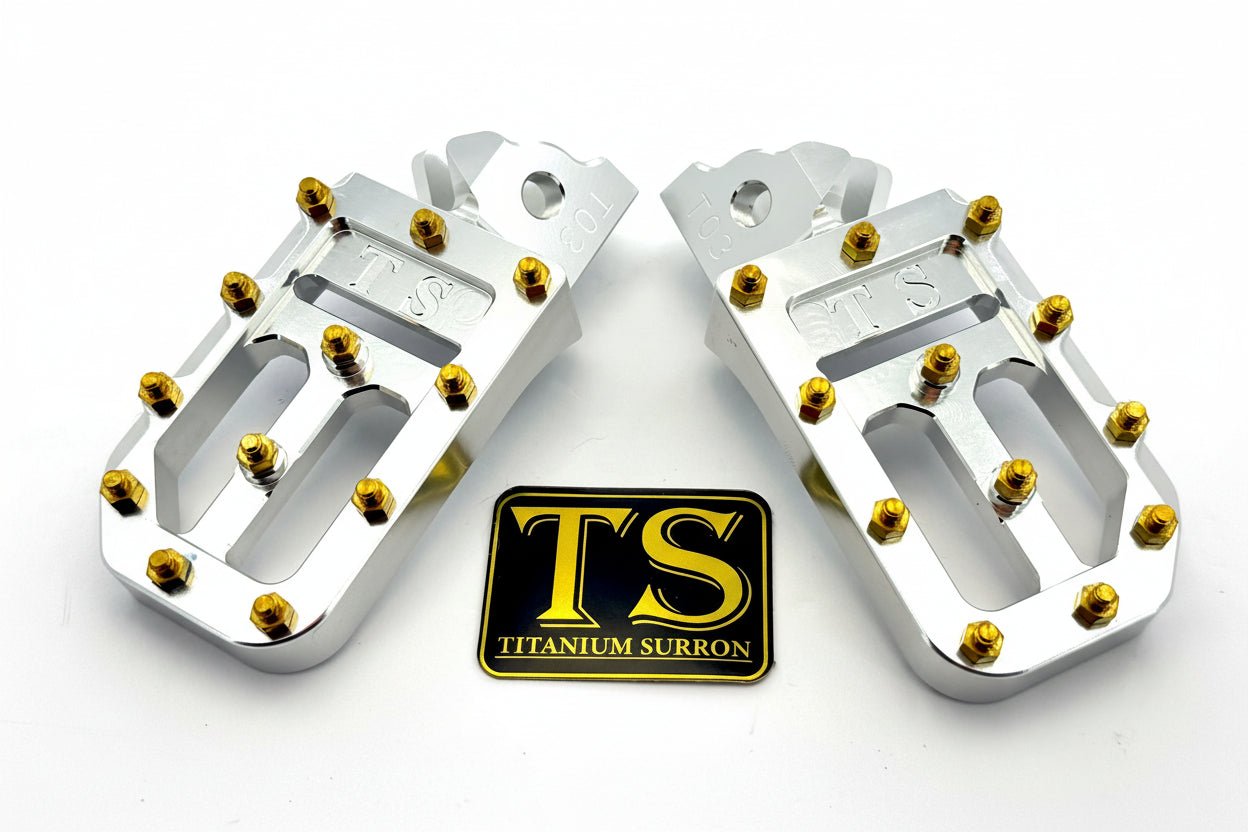 Titanium Surron custom foot pegs with titanium grips for Surron and light e-moto bikes, featuring durable metal construction and grip surface.