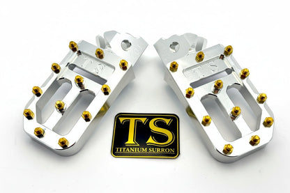 Titanium Surron custom foot pegs with titanium grips for Surron and light e-moto bikes, featuring durable metal construction and grip surface.