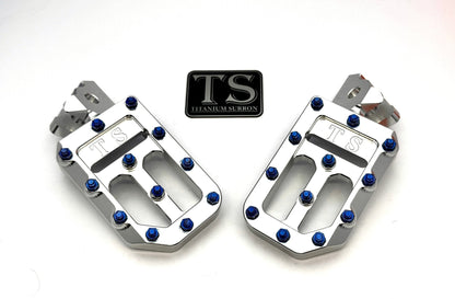 Titanium Surron custom foot pegs with titanium grips for Surron, Talaria, and Altis electric motorcycles, featuring lightweight alloy construction.