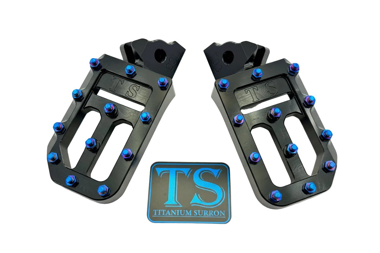 Titanium Surron custom foot pegs with titanium grips for Surron and light e-moto bikes, featuring durable metallic finish.