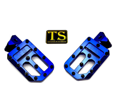 Titanium Surron custom foot pegs with titanium grips for Surron and light e-moto, showing durable metal construction and grip surface.