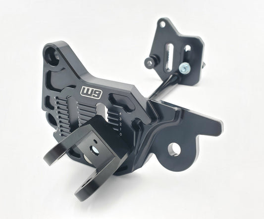 Warp9Racing adjustable foot peg mount for Sur-ron LBX and 79Bike, shown mounted on the bike with a sturdy metal construction.