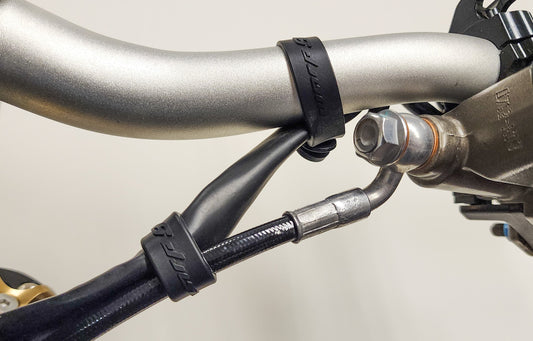 Warp9Racing Surron bar straps, black lightweight motorcycle handlebar straps with secure fastening for off-road riding.